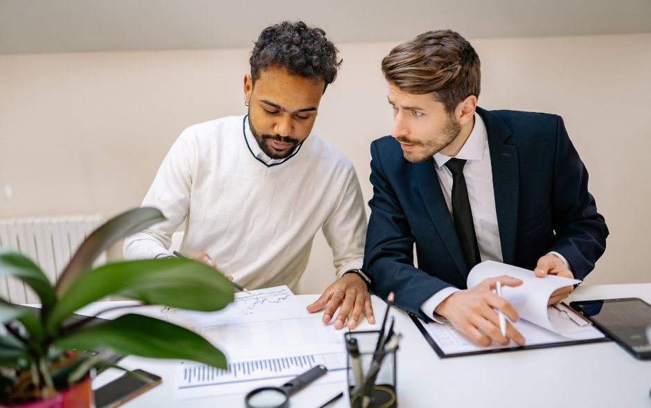 Two gentleman at a work desk.
